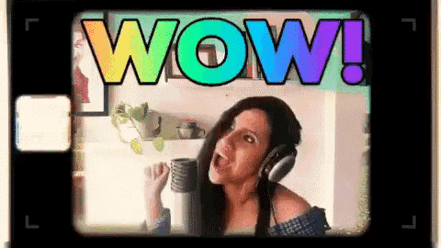 a woman wearing headphones is singing into a microphone in front of a screen that says wow !