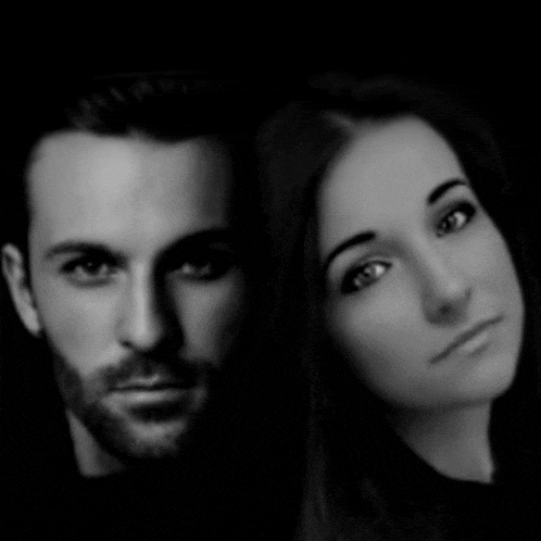 a black and white photo of a man and a woman looking at the camera