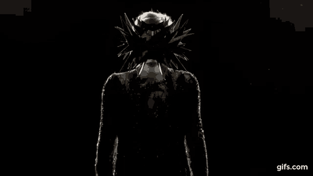 a person is standing in the dark wearing a helmet and a crown .