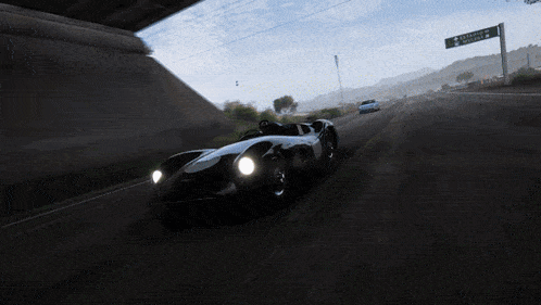 a car is driving down a road under a bridge with a sign that says " california " on it