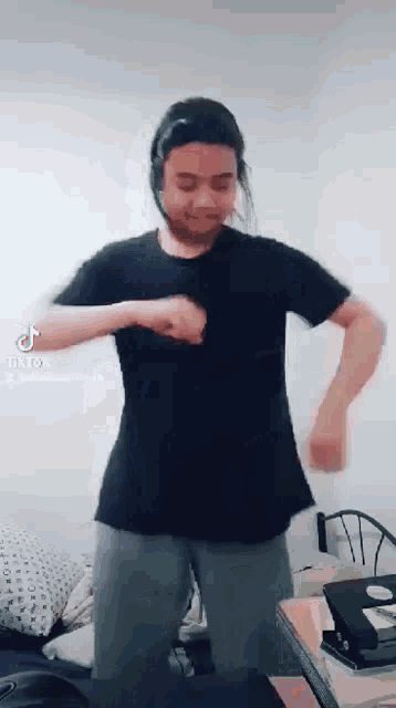 a man wearing headphones is dancing in a room .