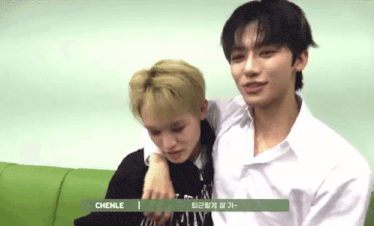two young men sitting next to each other with chenle written on the bottom of the screen