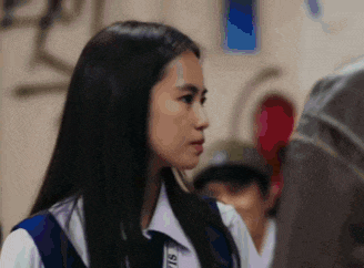 a young girl in a school uniform is standing next to a man in a jacket .
