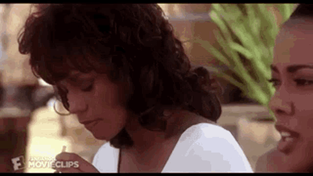 two women are sitting next to each other in a restaurant .