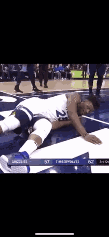 a basketball player laying on the floor during a game between the grizzlies and the timberwolves