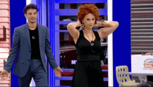 a man in a suit is standing next to a woman in a black dress .