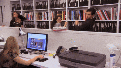 a woman sits at a desk in front of a computer monitor
