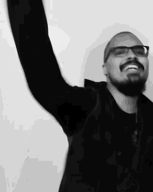 a man with glasses and a mustache is wearing a black sweater