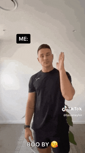 a man in a black shirt is making a boo by gesture