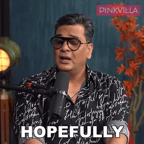 a man wearing glasses is talking into a microphone and the word hopefully is on the screen