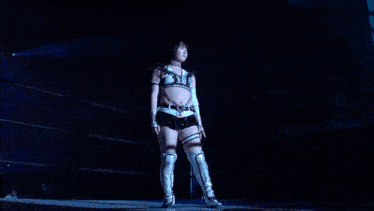 a woman in a wrestling outfit is making a thumbs down gesture in a dark room .