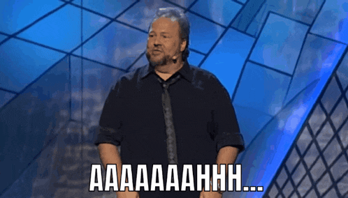 a man in a black shirt and tie is giving a speech and says aaa
