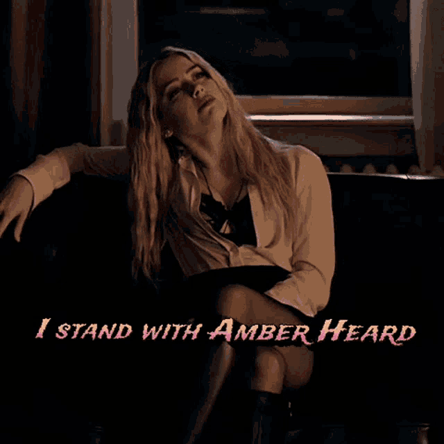 a woman sitting on a couch with the words " i stand with amber heard " written above her