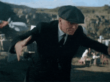 a man in a suit and hat is dancing .