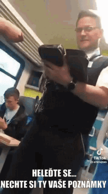 a man in a uniform is holding a bag in his hand with the caption heledete se nechte si ty svoje poznamky