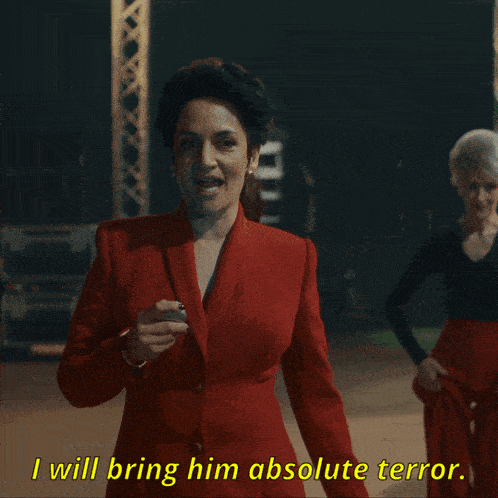 a woman in a red suit is saying i will bring him absolute terror