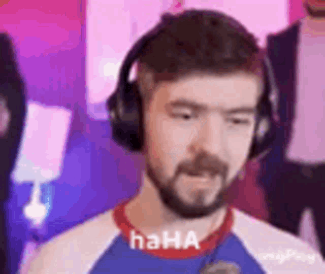 a man with a beard wearing headphones and a shirt that says `` haha '' .