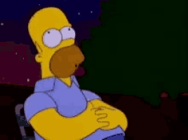 homer simpson is sitting in a chair with his hands on his stomach