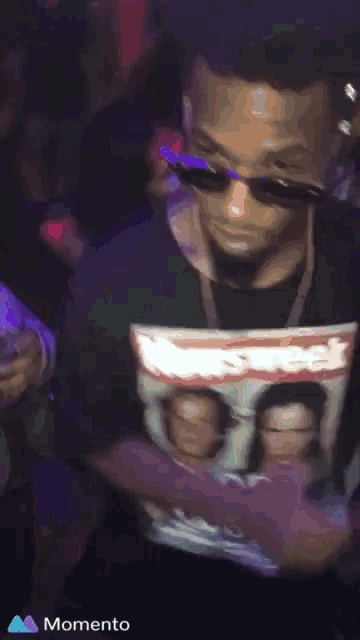 a man wearing sunglasses and a shirt that says supreme