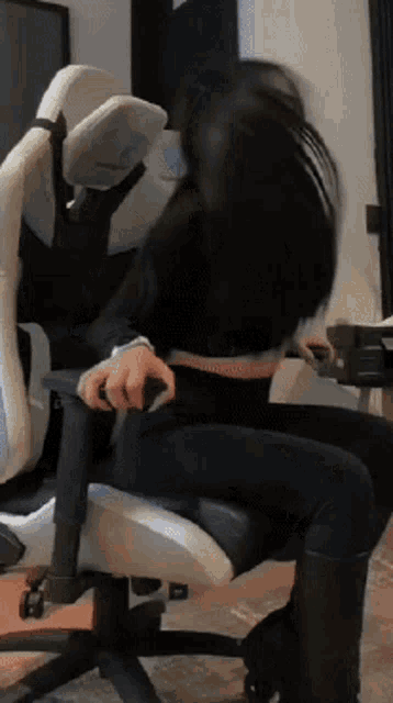 a woman is sitting in a chair with her hair blowing in the wind