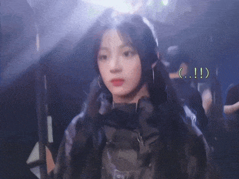 a young woman with long black hair is wearing a black jacket and earrings .