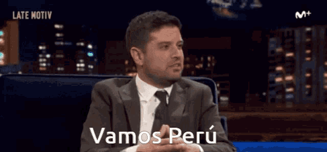 a man in a suit and tie says " vamos perú "