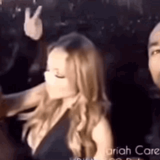 a woman is giving a peace sign in front of a man .