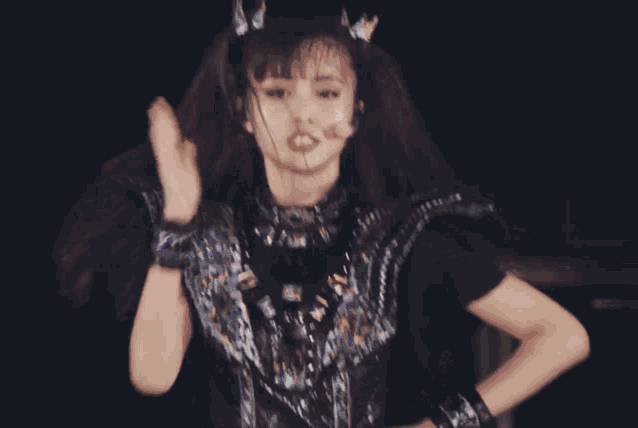 a girl with a crown on her head is wearing a black outfit