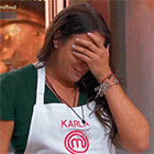 a woman wearing an apron with the letter m on it covering her face
