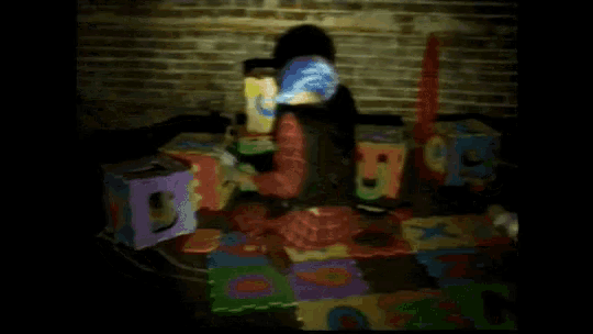 a woman in a clown costume is surrounded by alphabet blocks including the letter d