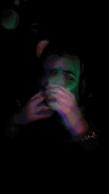 a blurry picture of a person 's face with a rainbow of colors