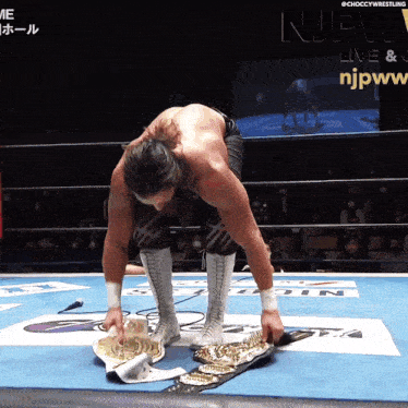 a man in a wrestling ring with the njpw logo on the bottom