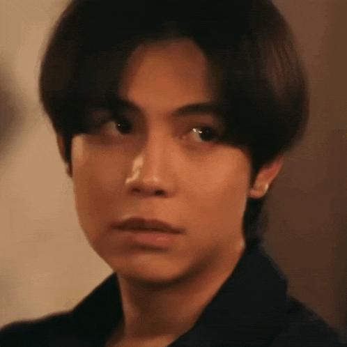 a close up of a young man 's face with a serious expression .