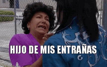a woman in a purple shirt is crying while a man in a blue shirt holds her