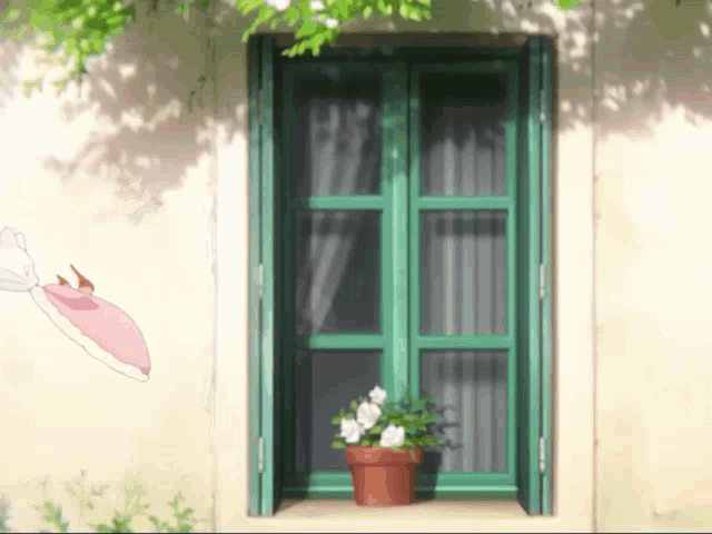 a green window with a pot of flowers on the window sill