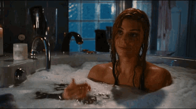 a woman is taking a bath in a bubble bath