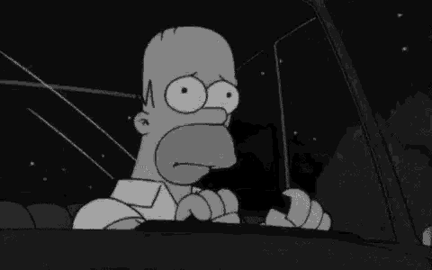 homer simpson is sitting in the driver 's seat of a car .
