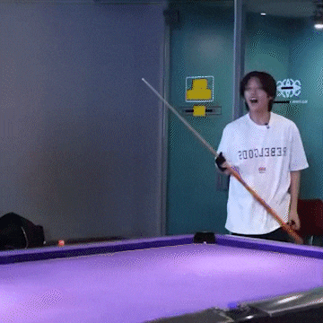 a man holding a pool cue with a shirt that says ' febercode ' on it