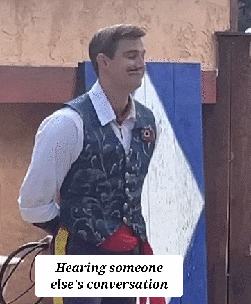 a man with a mustache is wearing a vest and a white shirt and is standing in front of a wall .