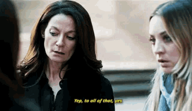two women are standing next to each other and one of them is talking to the other .