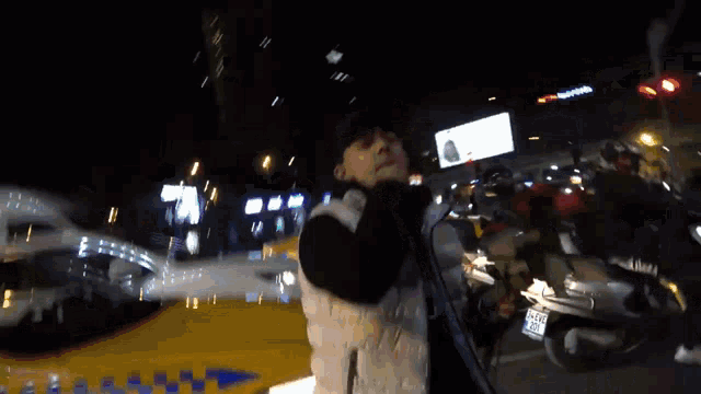 a man is holding a rose in front of a taxi that says taxi on the side