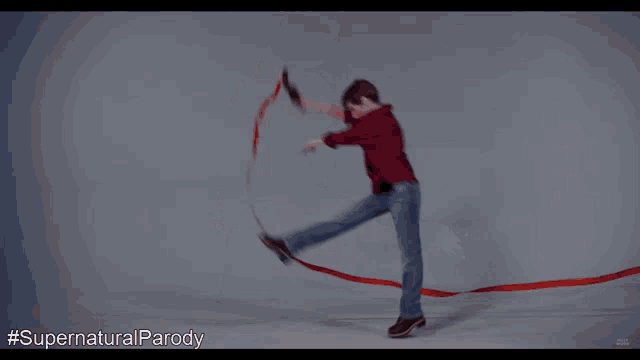 a man is dancing with a red ribbon and the hashtag #supernaturalparody