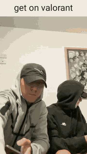 a man wearing a nike hat is sitting next to another man