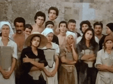 a group of people are standing next to each other with their arms crossed in front of a wall .