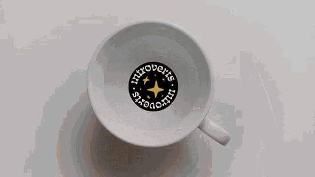 a cup of coffee with a logo that says introverts