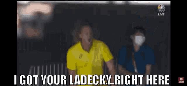 a man in a yellow shirt says " i got your ladecky right here " in front of a woman wearing a mask