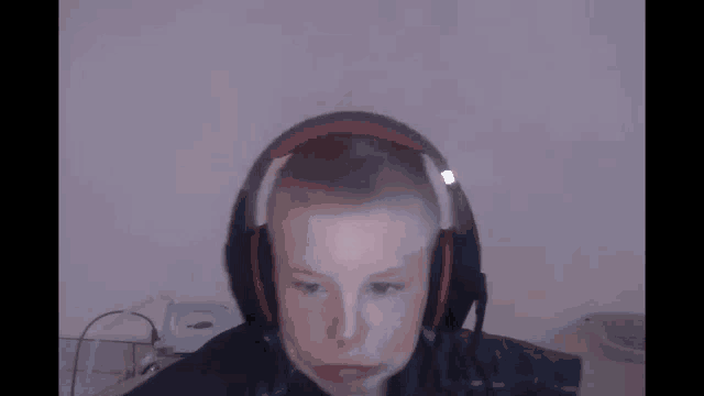 a young boy wearing headphones with a microphone on his head .