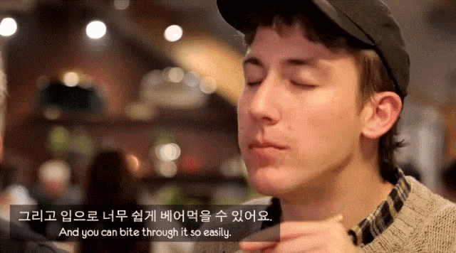 a man with his eyes closed is eating something with a caption that says and you can bite through it so easily