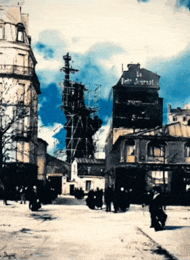 a statue of liberty is being built in front of a building that says le petit journal on it