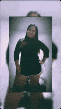 a woman in a black shirt and shorts is smiling